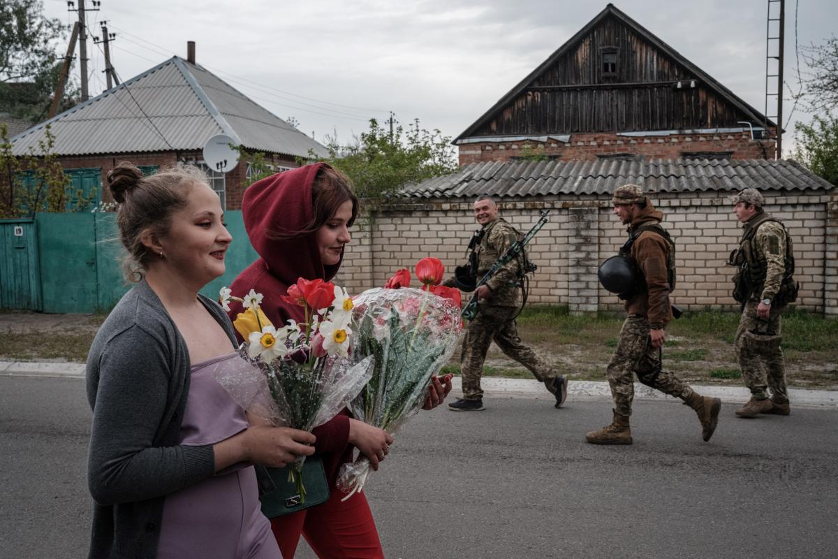 Egy lány néz ki egy buszból, miközben az orosz megszállás alatt álló zaporizzsjai területről származó családok érkeznek egy humanitárius konvojjal a belső menekültek regisztrációs és feldolgozó központjába Zaporizzsjában 2022. április 29-én, az Ukrajna el