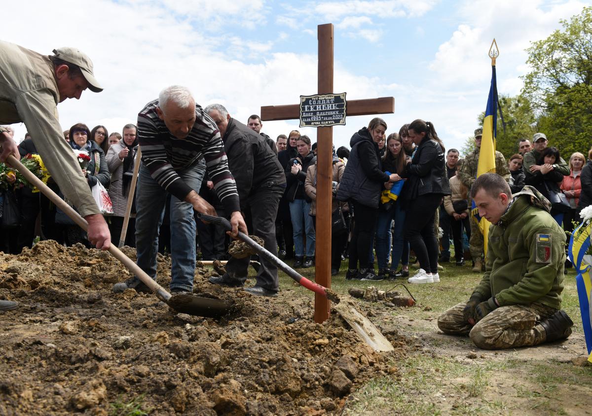 Egy lány néz ki egy buszból, miközben az orosz megszállás alatt álló zaporizzsjai területről származó családok érkeznek egy humanitárius konvojjal a belső menekültek regisztrációs és feldolgozó központjába Zaporizzsjában 2022. április 29-én, az Ukrajna el