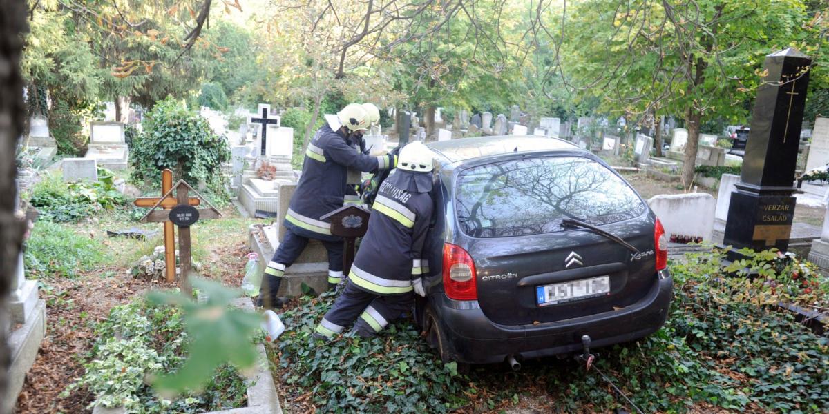 Tűzoltók dolgoznak az autó műszaki mentésén a Farkasréti temetőben