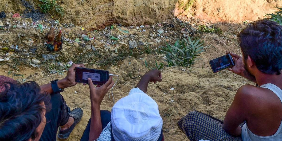 Rohingya menekültek Aun Szan Szu Kji kormányfő beszédét nézik mobiltelefonon