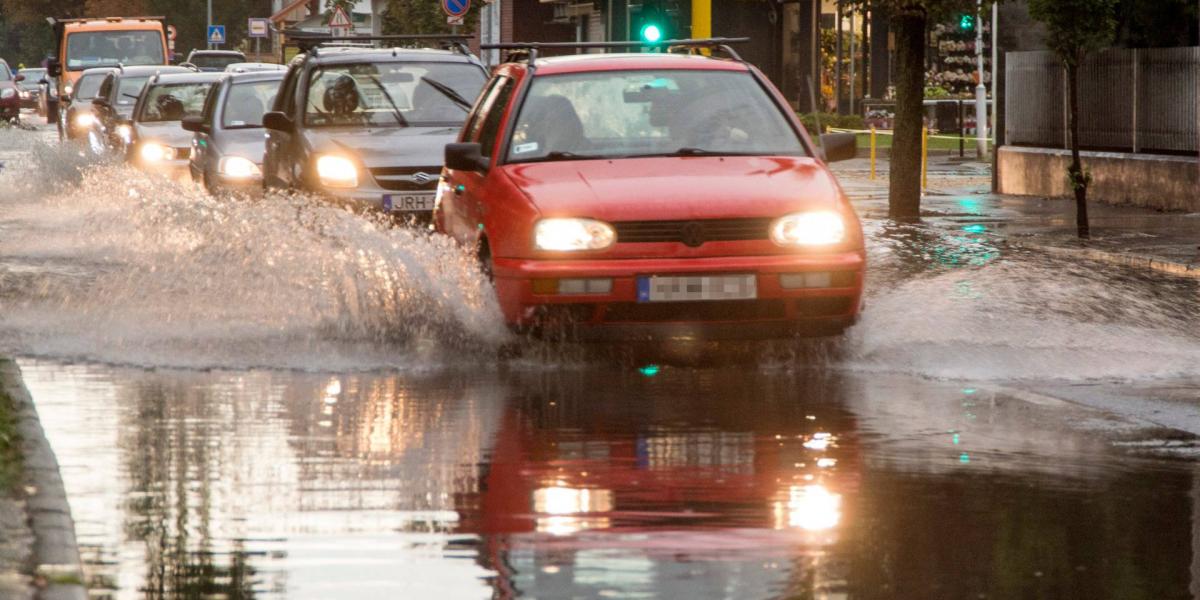 Autók haladnak a heves zápor után esővízzel borított győri Mónus Illés utcában augusztus 17-én