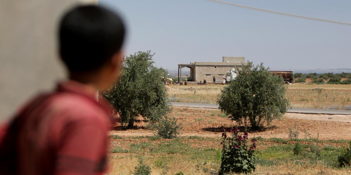 Egy fiú egy épületet néz, ahol az amerikai koalíciós erők egy éjszakai légi hadműveletet hajtottak végre Humayra faluban, a Ghandoura körzetben, Szíria északi részén, Aleppó tartományban, 2022. június 16-án.