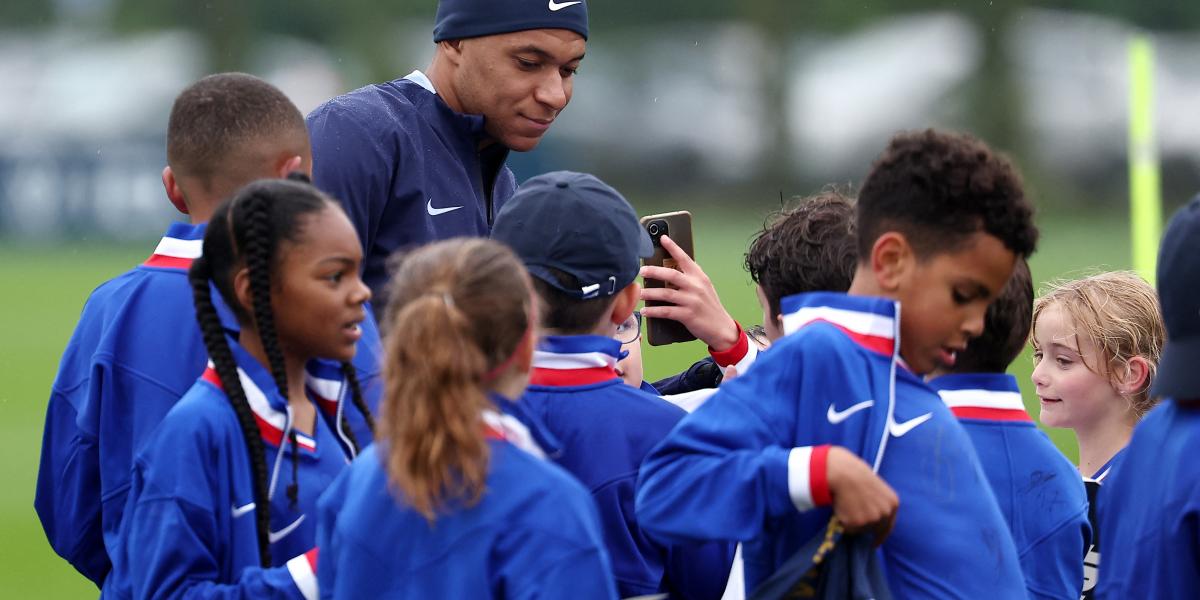 Kylian Mbappé rajongó gyermekek gyűrűjében a francia válogatott edzése előtt