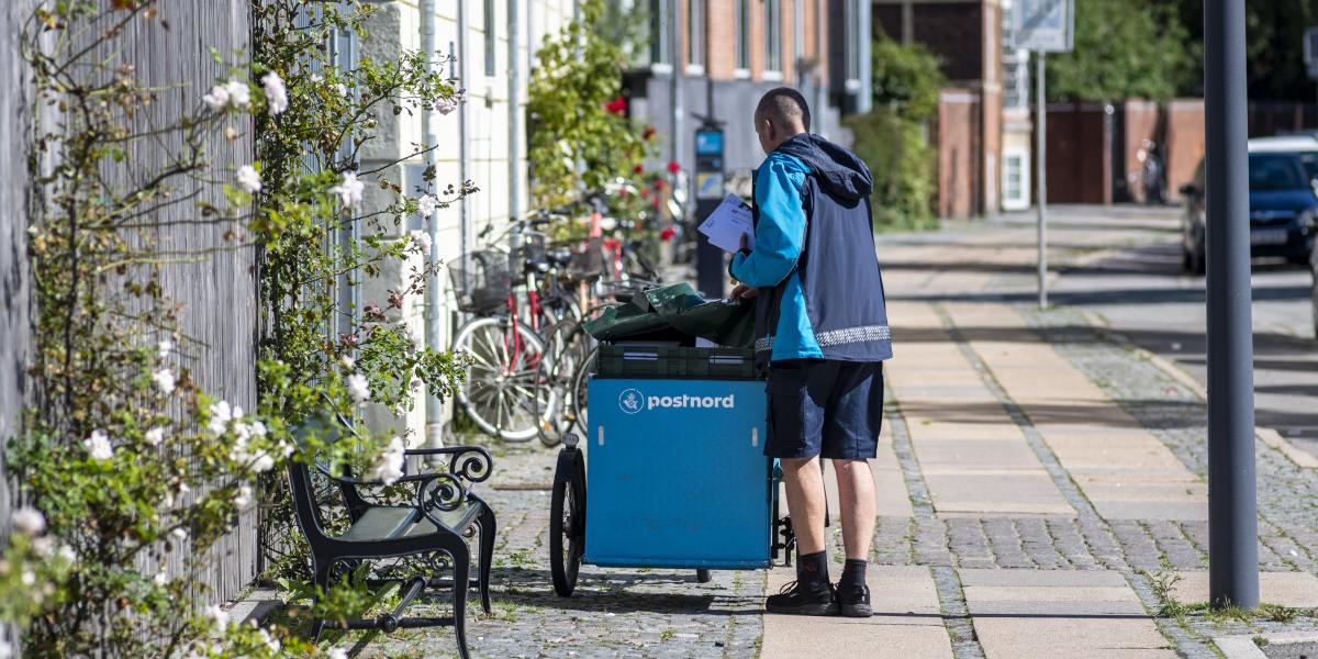 A dán állami Postnord postása leveleket kézbesít Koppenhágában 2020. augusztus 31-én.