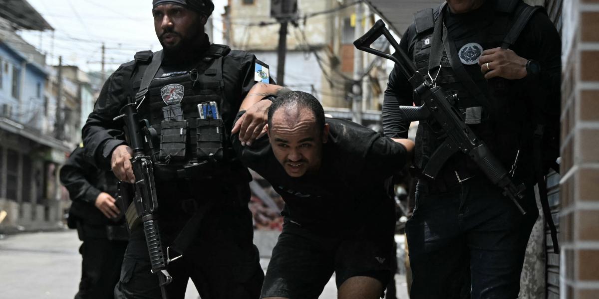 Az egyik razzia során letartóztatott gyanúsítottat kísérik a rendőrök Rio de Janeiró egyik szegénynegyedében, 2025. október 28-án.