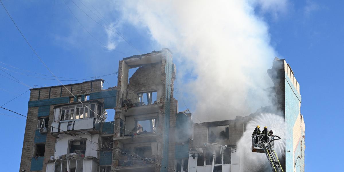 Ukrán mentőalakulatok küzdenek egy súlyosan megrongálódott lakóépület lángjaival az orosz légicsapás után.