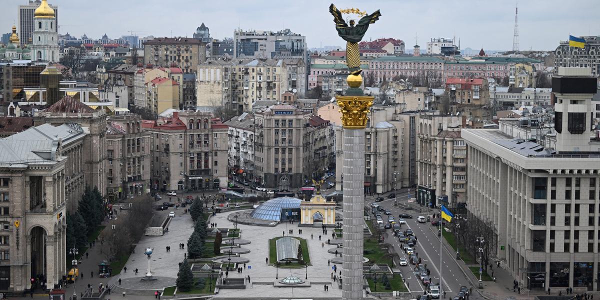 Gyalogosok és autósok egy perc néma csenddel tisztelegnek, miközben egy meggyilkolt ukrán katona holttestét halottaskocsival szállítják el a kijevi Függetlenség téren