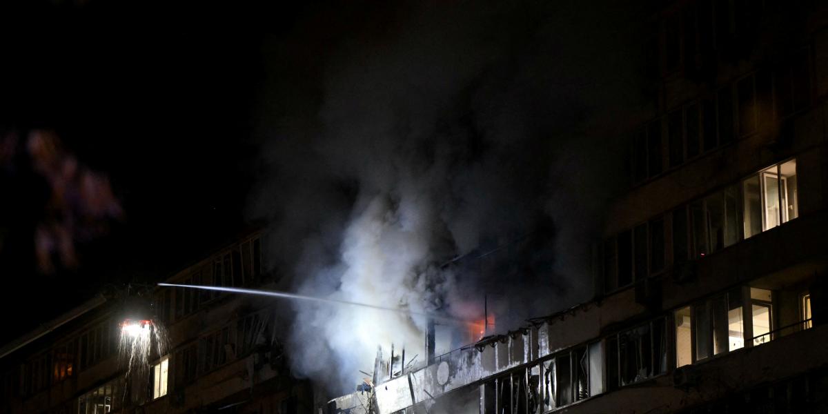 Ukrán mentőalakulatok oltják a kijevi légitámadást követően keletkezett lakóépület tüzet.