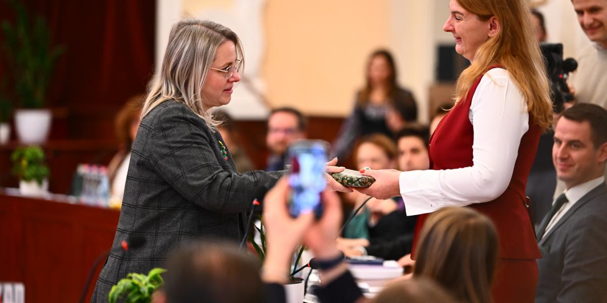 Szepesfalvy Anna adja át Baranyi Krisztina ajándékát, a Fővárosi Közgyűlésen, december 17-én
