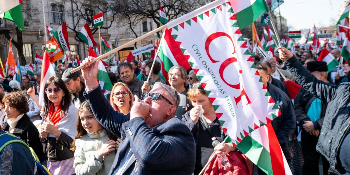 A Békemenet egyik résztvevője CÖF zászlóval sétál 2026. március 15-én