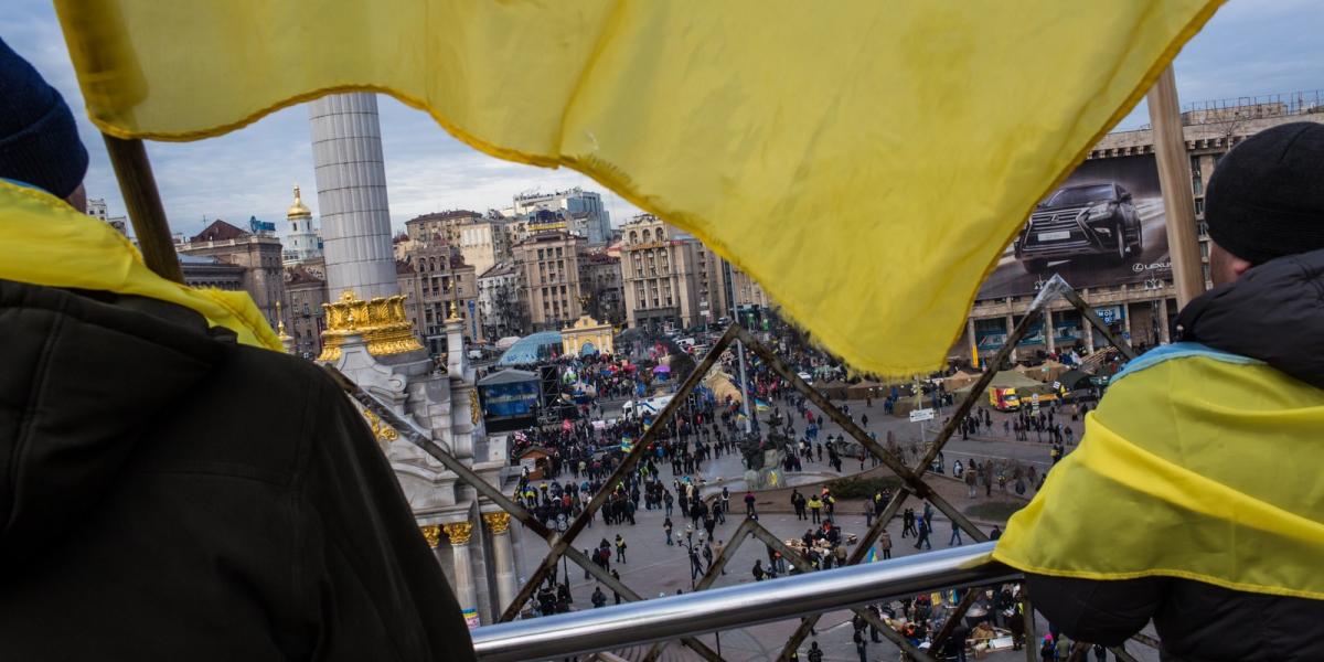 Ukrán zászlóba "öltözött" kormányellenes tüntetők figyelik demonstráló társaikat a Függetlenség terén. Fotó: Brendan Hoffman/ Ge