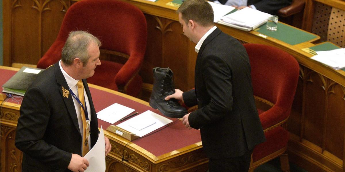 Harangozó Tamás egy bakancsot tesz Orbán Viktor miniszterelnök asztalára az Országgyűlés plenáris ülésén. MTI Fotó: Máthé Zoltán