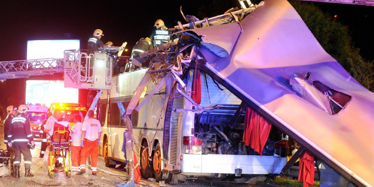 Tűzoltók, mentősök dolgoznak az ütközés után szétnyíló busz körül  Fotó: MTI/Mihádák Zoltán