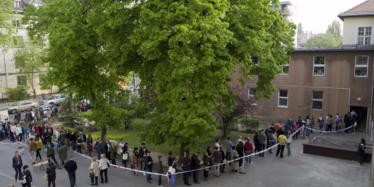 Átjelentkezők állnak sorba a Bocskai út és Nagyszőlős utca sarkánál, az újbudai Bocskai István Általános Iskola épületében kiala