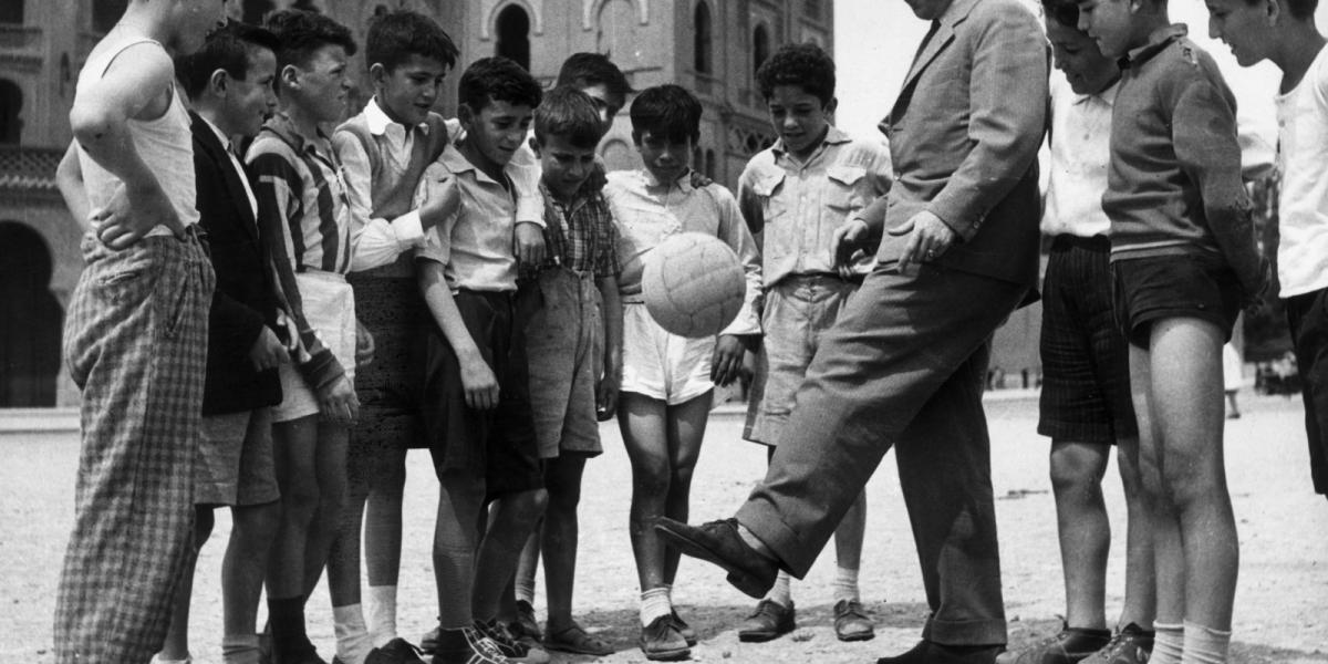 Puskás 1961-ben madridi gyerekeknek mutatja, hogyan kell ballal dekázni. Fotó: Keystone/Hulton Archive/Getty Images.