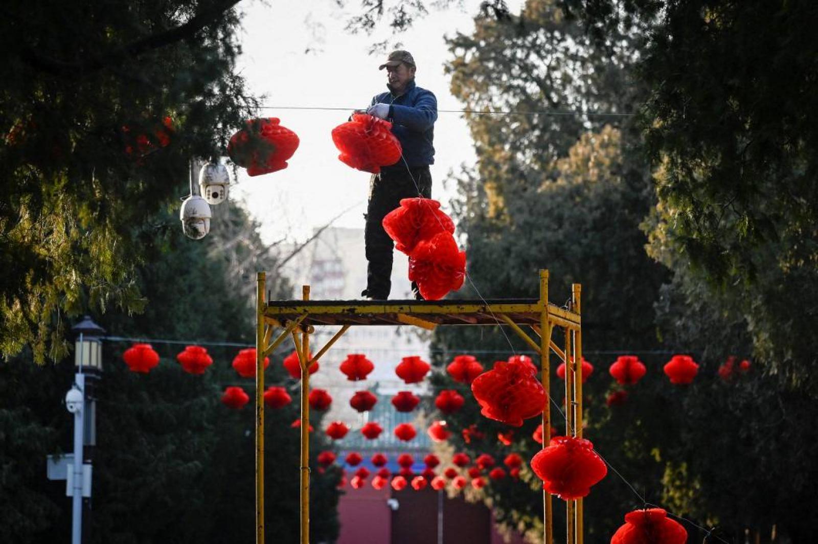 Egy férfi megtisztítja a tigris díszét, amely egy templom falát díszíti a közép-jávai Semarangban 2022. január 27-én, a holdújév előtt, amely február 1-jén vezeti be a tigris évét.