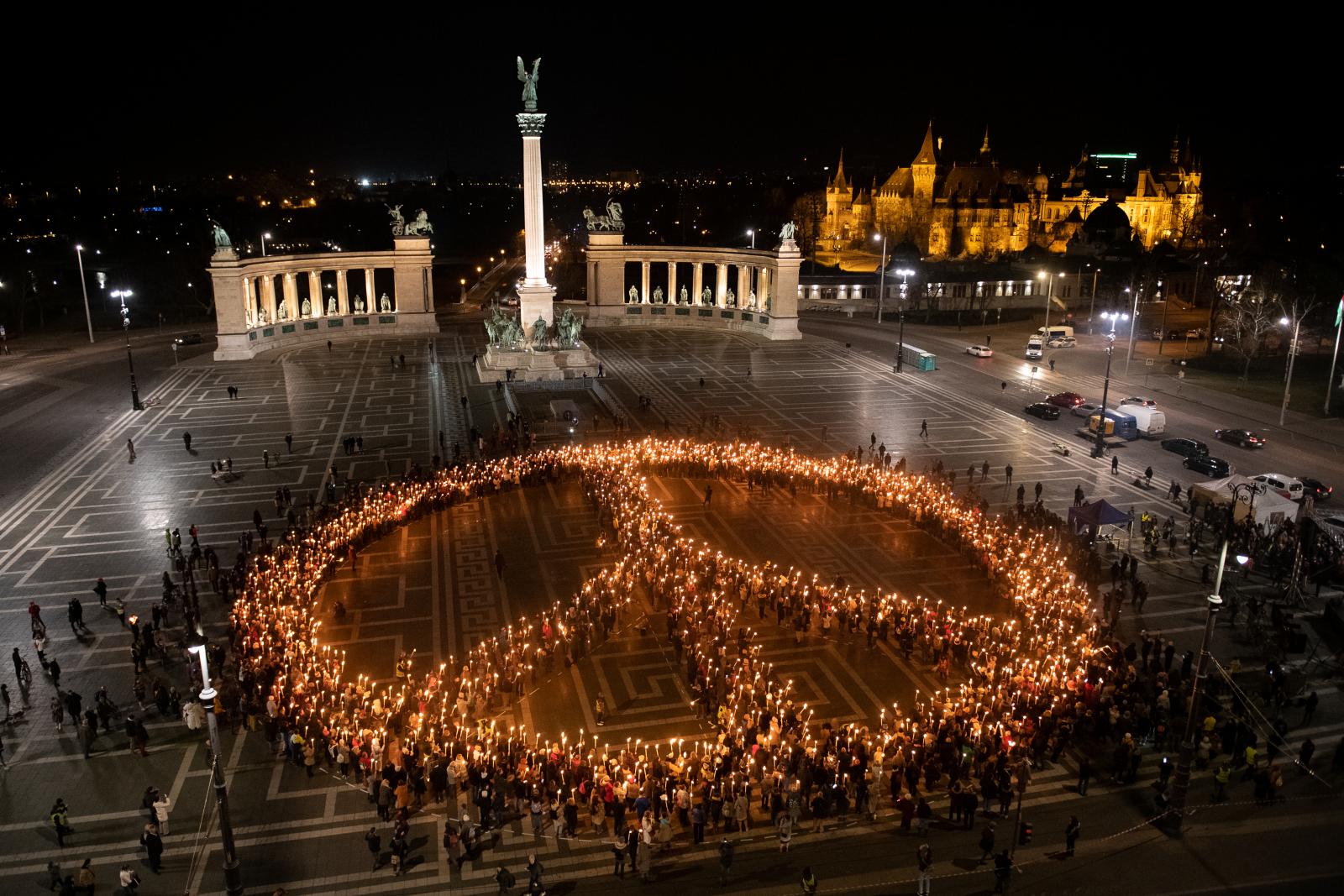 Civil szervezetek béke jelet formálnak fáklyákból Budapesten a Hősök terén szolidaritásul Ukrajnával 2022. március 9-én