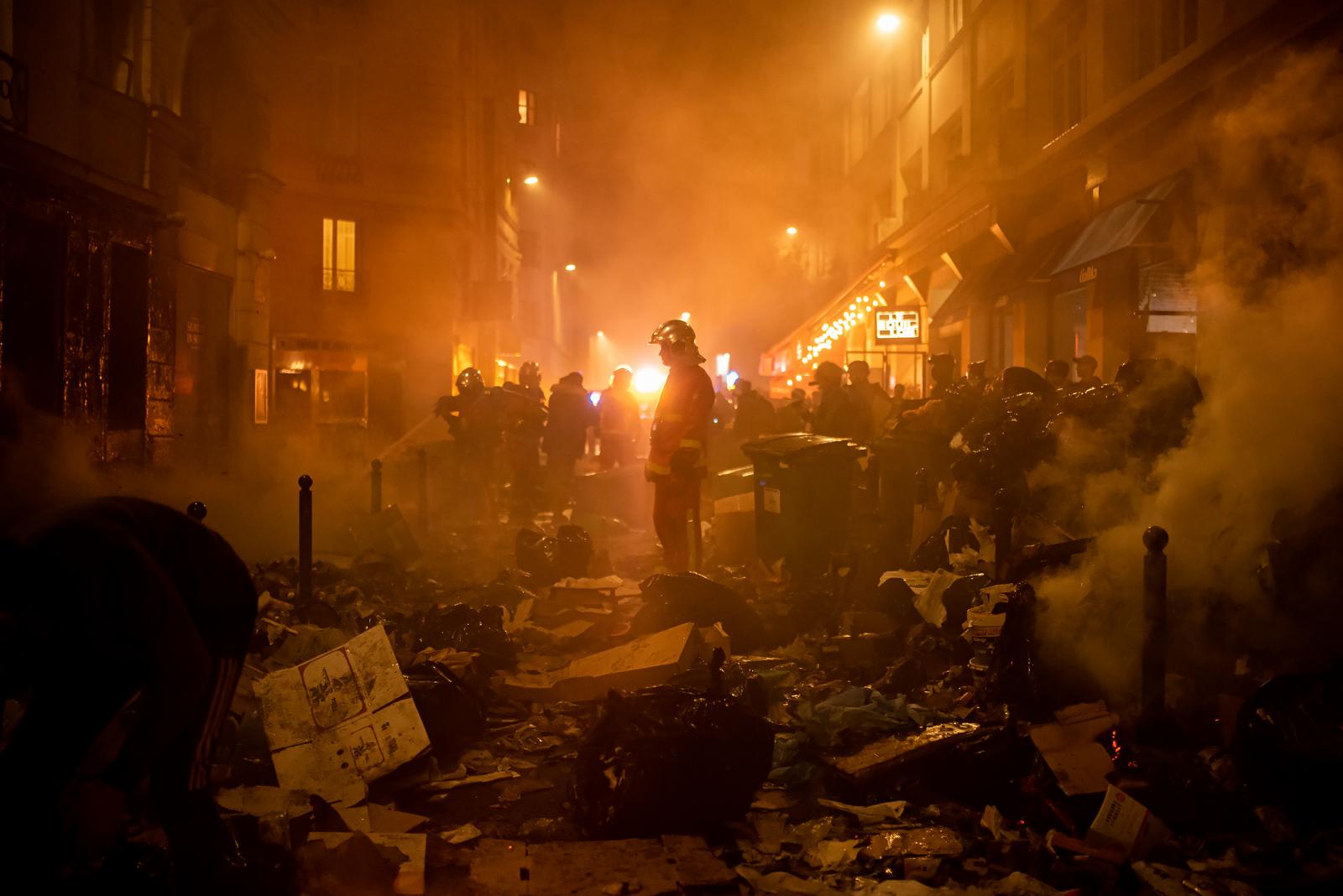 Könnygázgránátot rúg vissza a rendőrség felé egy francia tüntető egy héttel a nyugdíjreform szavazás nélküli elfogadtatása után.