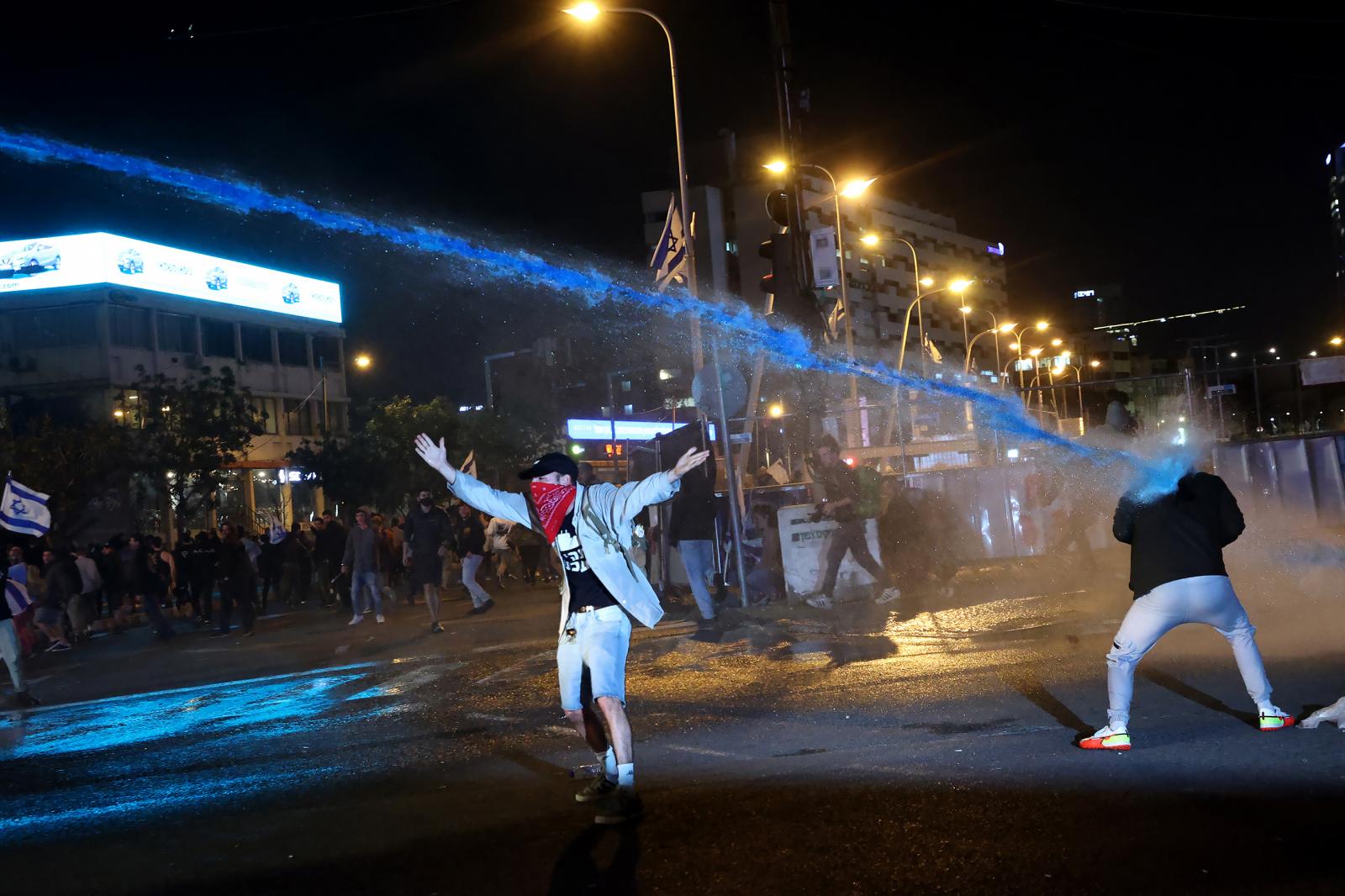 Könnygázgránátot rúg vissza a rendőrség felé egy francia tüntető egy héttel a nyugdíjreform szavazás nélküli elfogadtatása után.