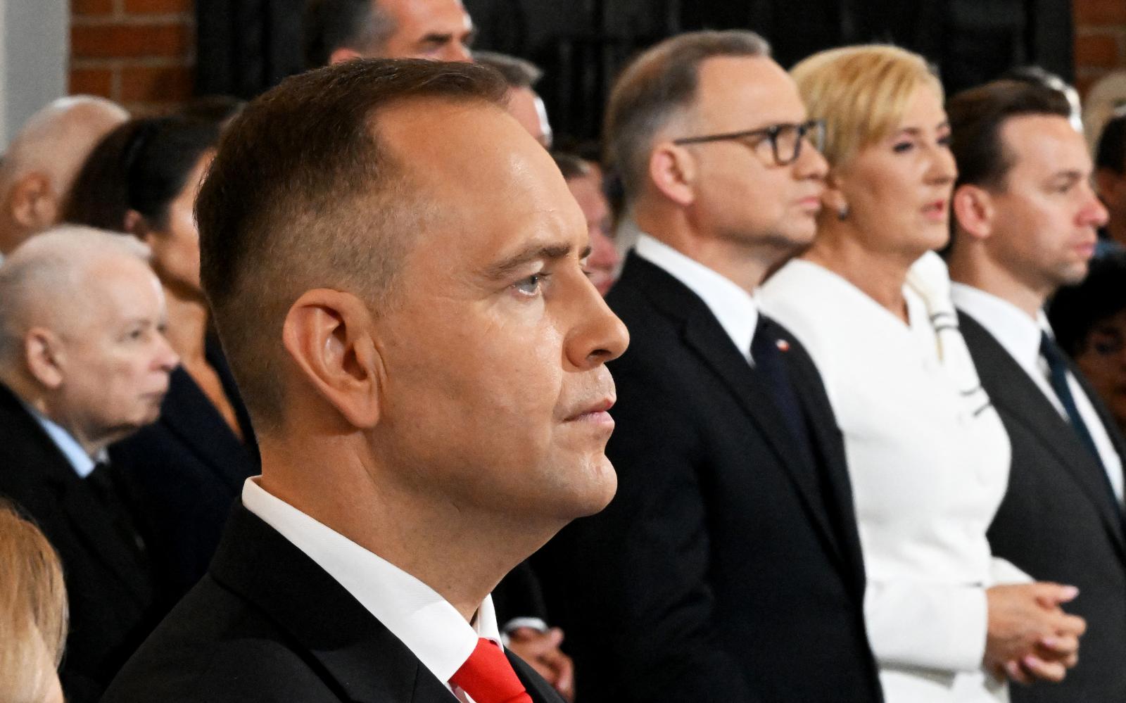 Karol Nawrocki (elöl) a háttérben  a kép bal szélén Jarosław Kaczyńskivel az államfő beiktatási miséjén