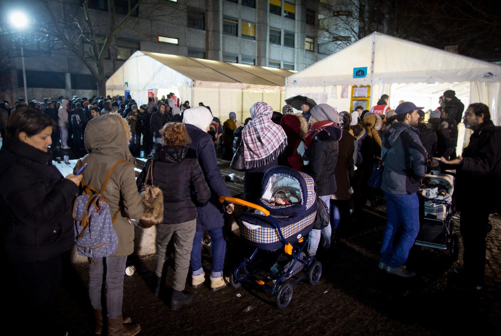 Menekültkérők sorban állnak az Egészségügyi és Szociális Ügyek Állami Hivatalának regisztrációs központja előtt Berlinben, 2015. december 21-én.