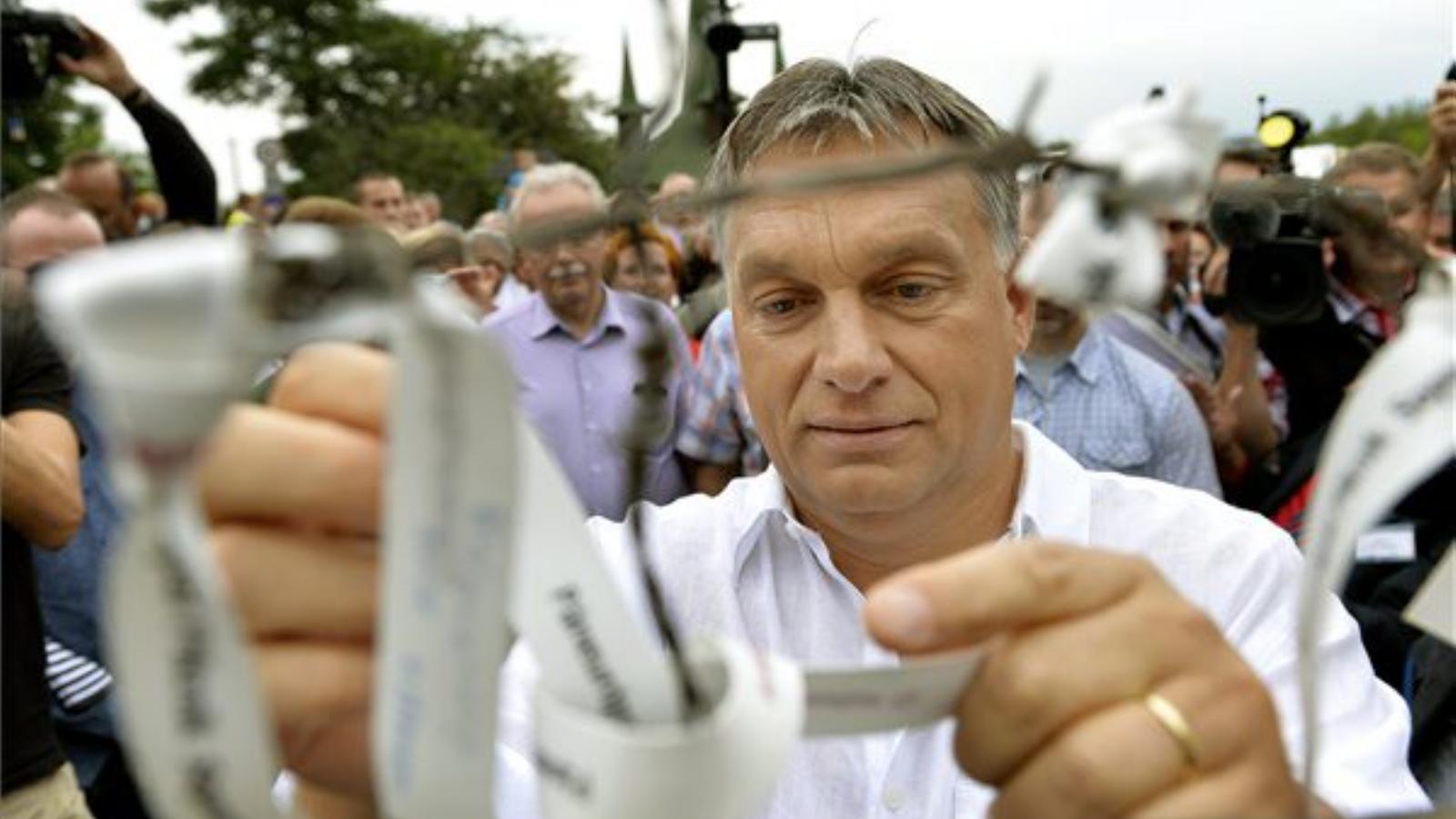 Orbán Viktor miniszterelnök egy egykori határkapura köt fel egy emlékszalagot a páneurópai piknik 25. évfordulóján a fertőrákosi