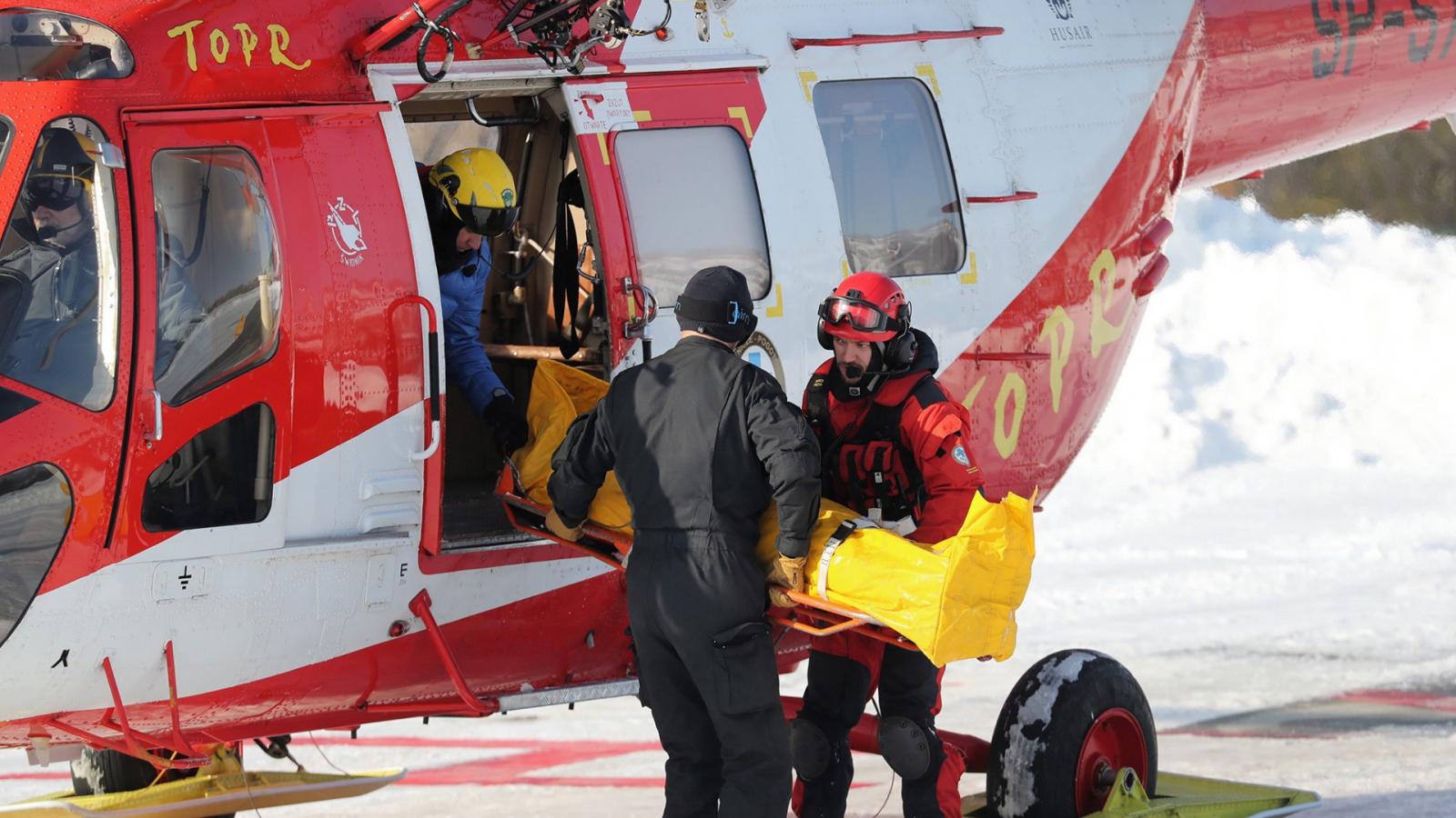 Sebesültet visznek a Tátrai Önkéntes Mentőszolgálat helikopteréhez a lengyel Tátrában 2019. január 30-án, miután lavina zúdult l