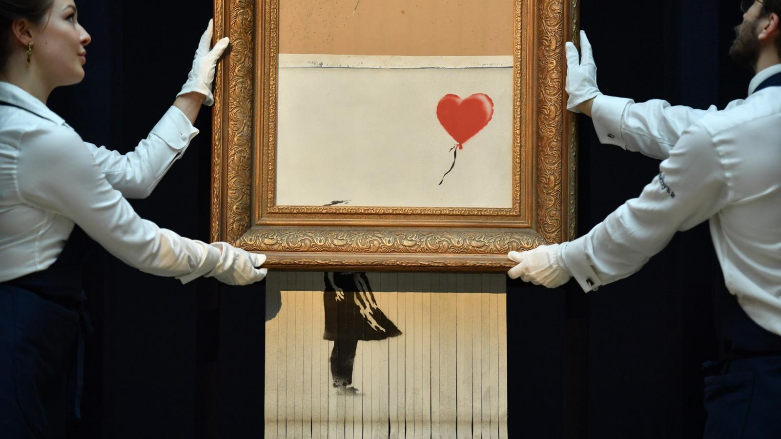 Új műalkotás született a Sotheby`s egyik árverésén, amikor a híres street art művész, Banksy egyik képe félig ledarálta magát