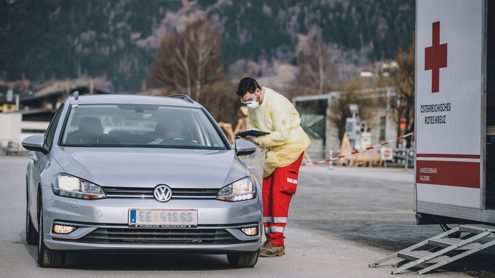 Az osztrák Vöröskereszt munkatársa mintát vesz egy drive-in tesztállomáson Schuettdorfban