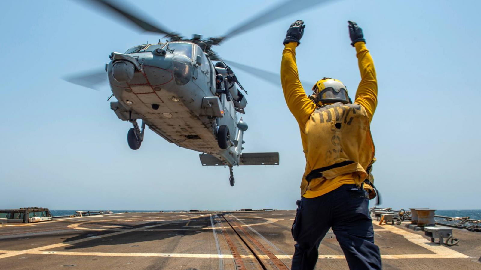 Seahawk amerikai harci helikoptert irányít egy tengerész az USS Bainbridge  rombolóhajó fedélzetén. Képünk illusztráció