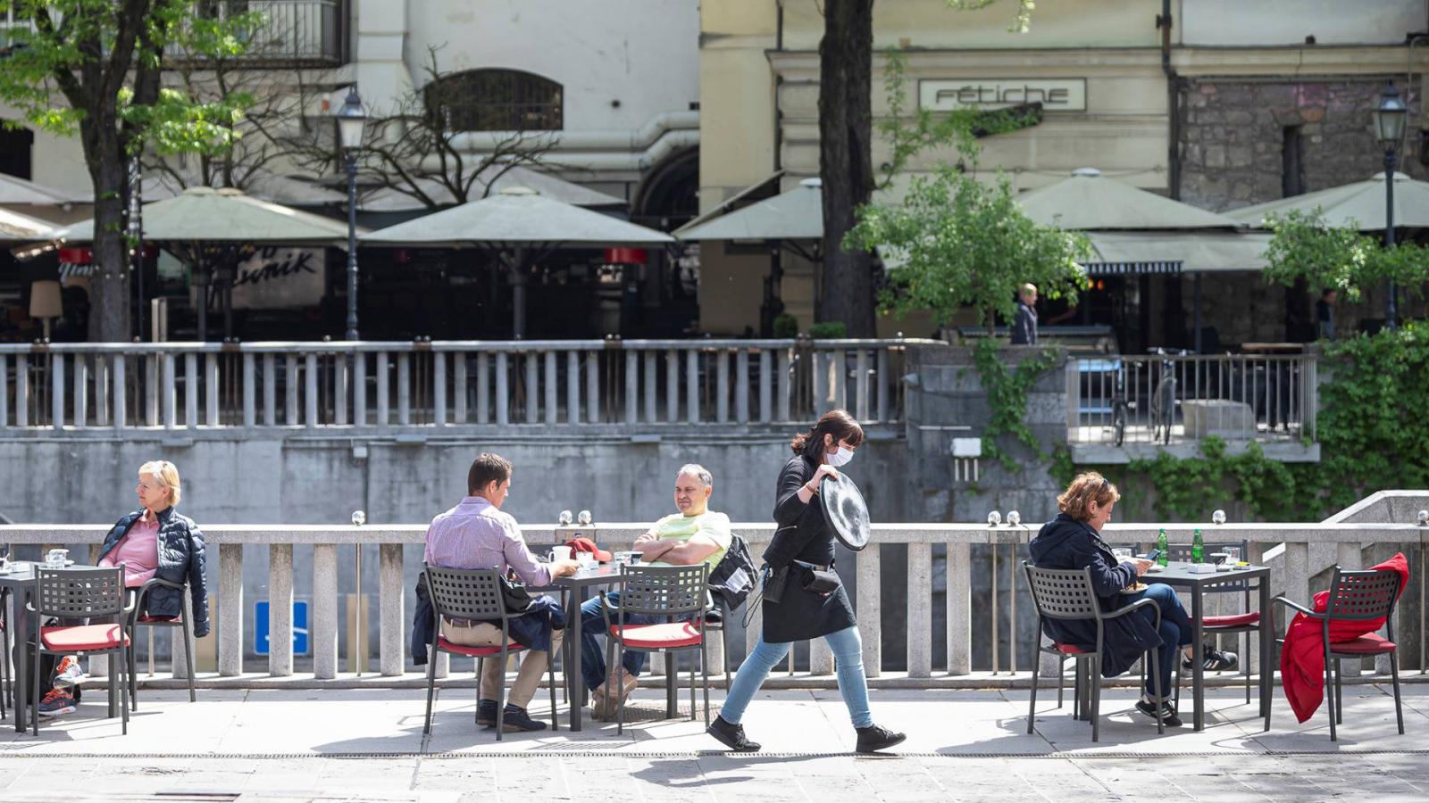 Vendégek egy újranyitott ljubjanai kávézó teraszán