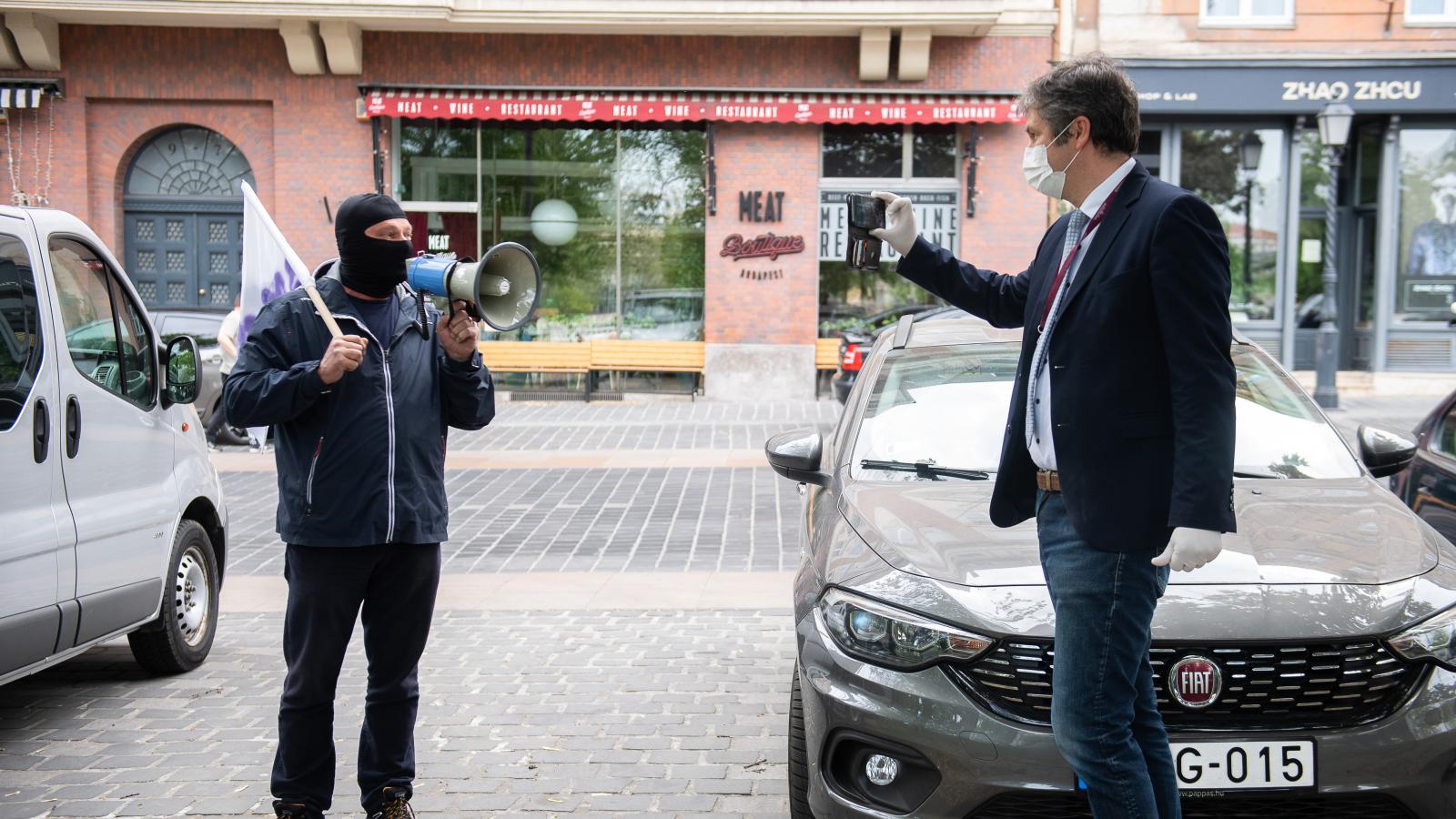 Hadházy Ákos ellenzéki képviselő és egy ellene tüntető a április 27-i dudálós tüntetésen Budapesten a Clark Ádám téren