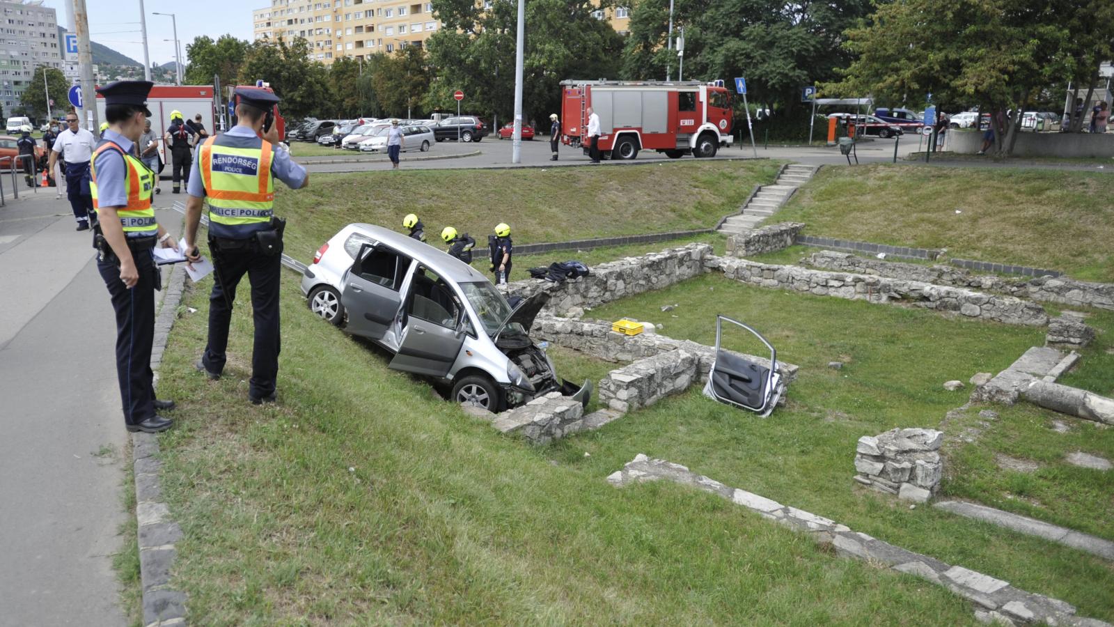 Rendőrök méregetik a romok között landoló autót a fővárosi Flórián téren, 2020. július 29-én