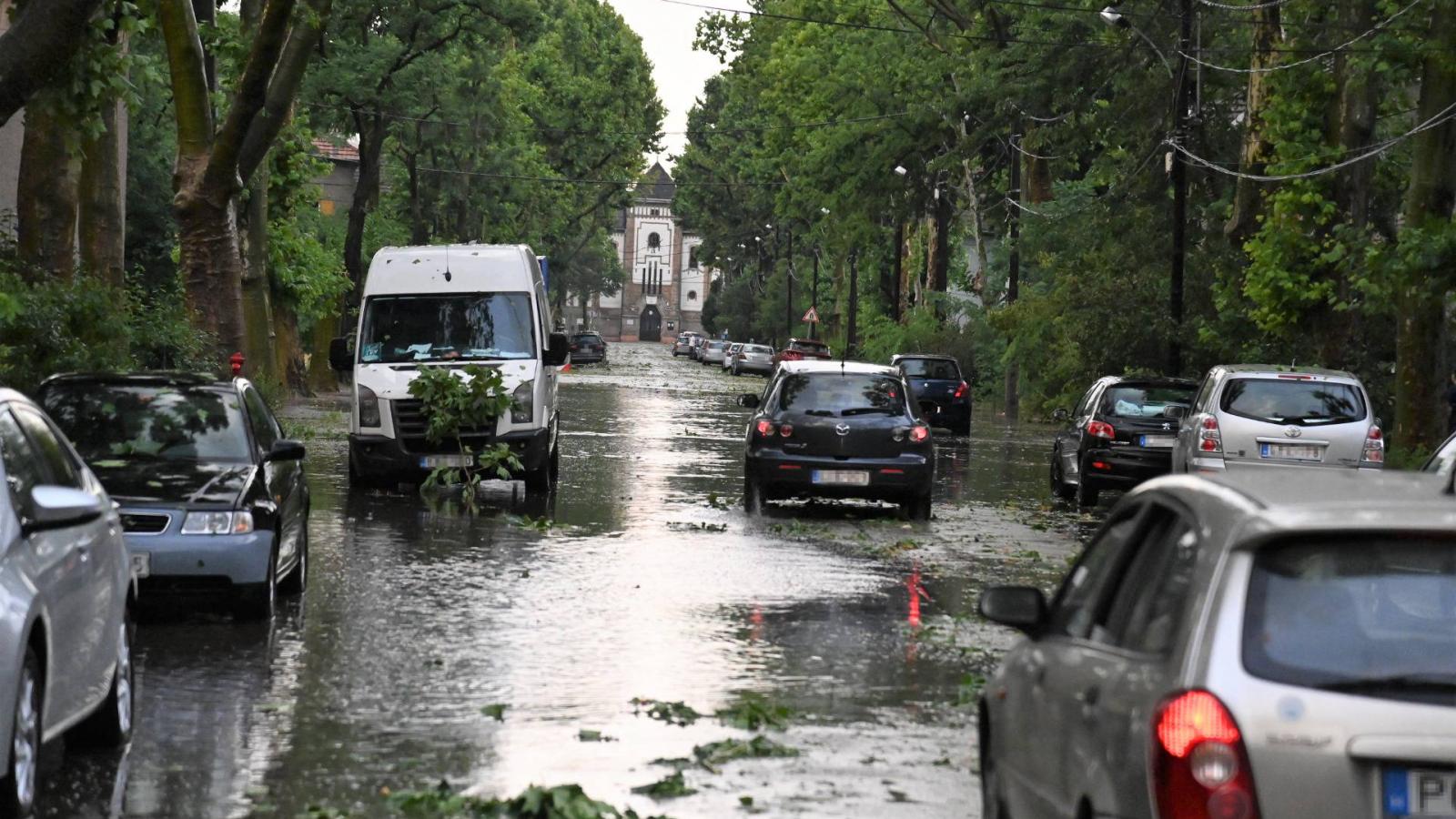 Autók a felhőszakadás után esővízzel elárasztott úton Budapesten, az Illatos úton