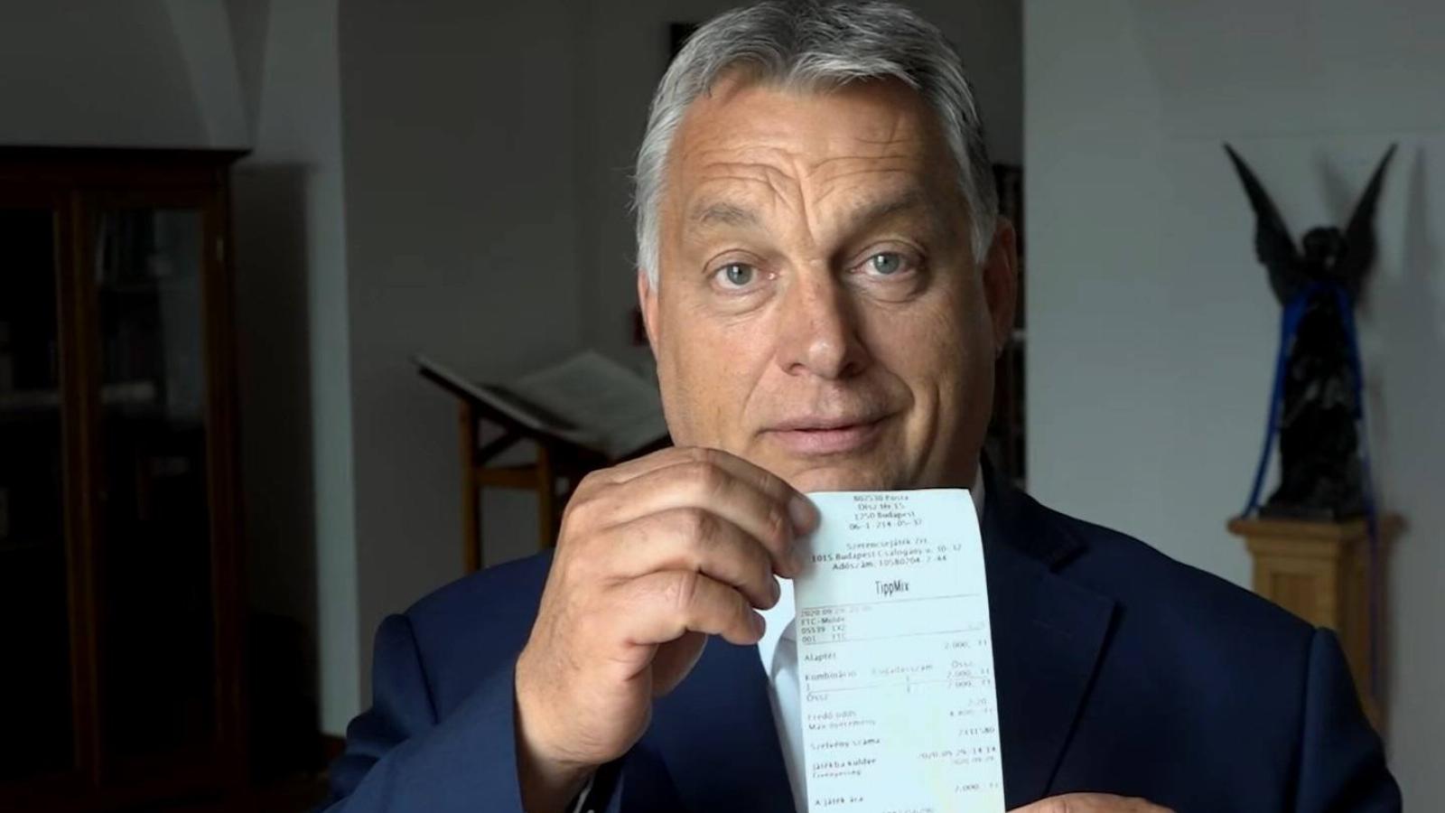 Orbán Viktor, kezében egy 2000 forintos szelvénnyel