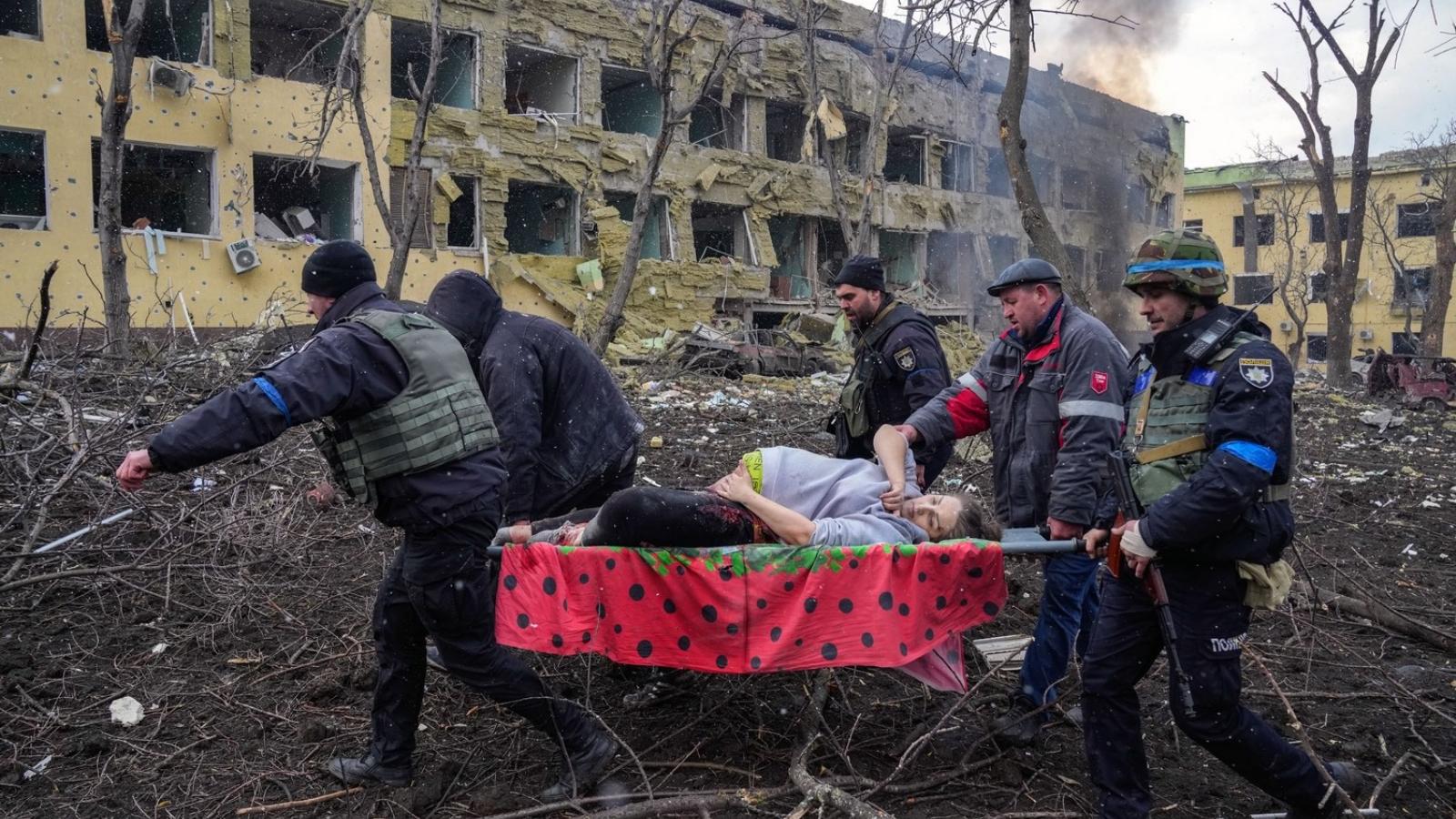 Evgeniy Maloletka díjnyertes fotóján az ukrán mentőszolgálat munkatársai és önkéntesek egy sérült terhes nőt menekítenek ki egy szülészeti kórházból Mariupolban