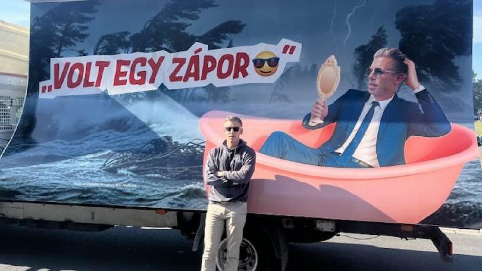 Magyar Péter a fideszes Nemzeti Ellenállási Mozgalom egyik őt lejárat plakátja előtt