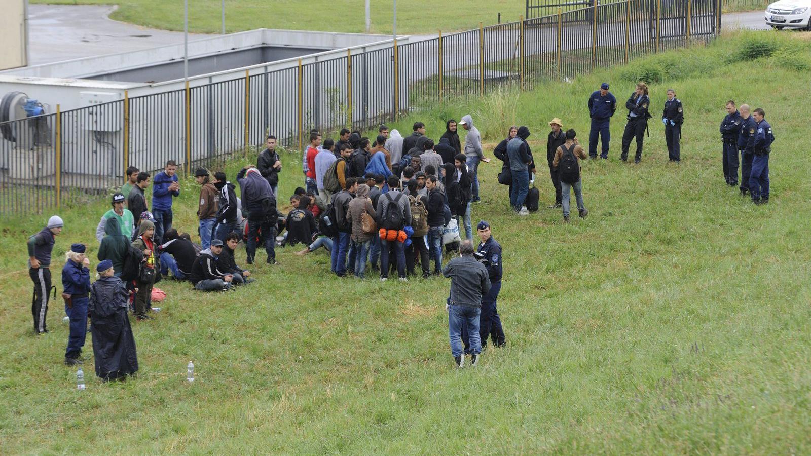 Rendőrök őriznek határsértőket, akiket a Tisza árterében, Szeged közelében fogtak el 2015. június 24-én. MTI Fotó: Kelemen Zoltá