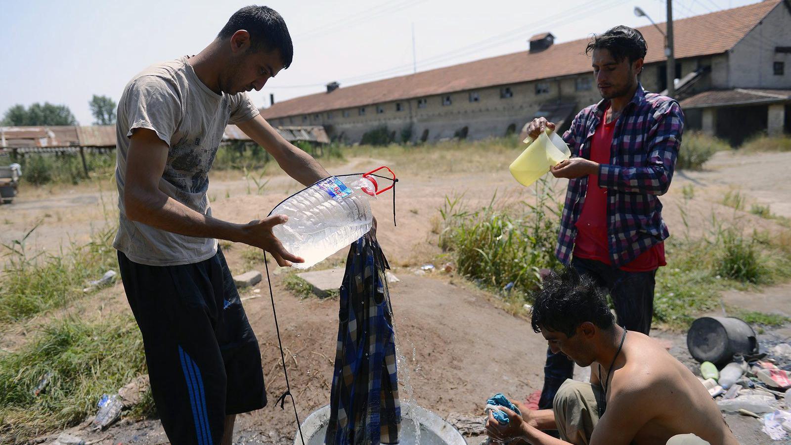 Afgán migránsok ruhát mosnak a 35 Celsius-fokot meghaladó hőségben a szabadkai szeméttelep közelében fekvő régi, elhagyatott tég