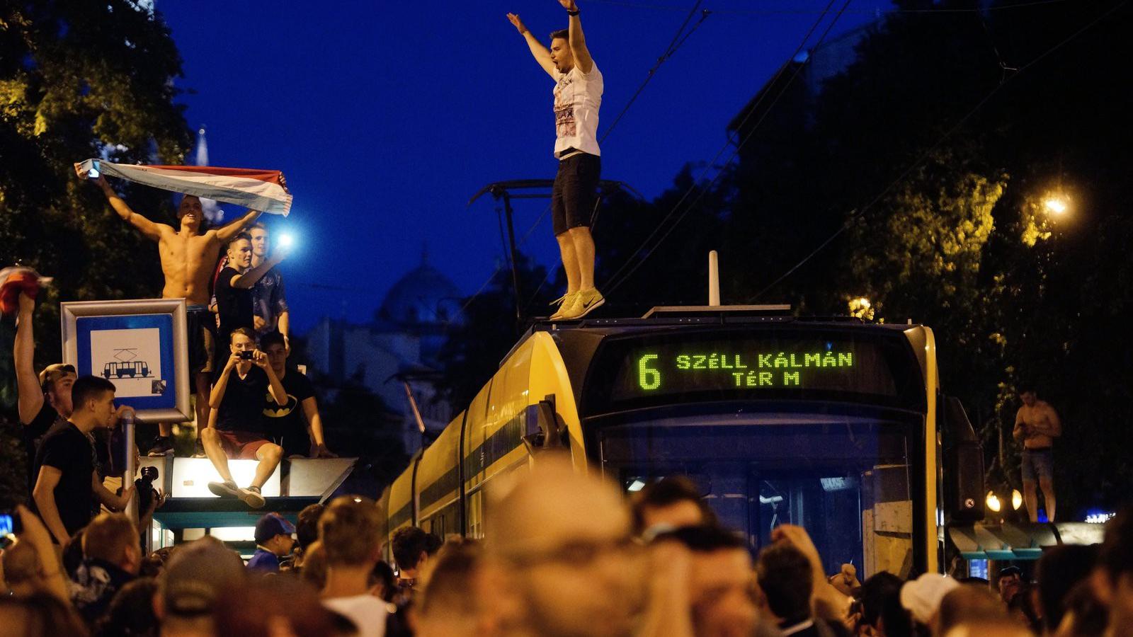  Villamos tetején áll egy szurkoló a magyar-izland után.  MTI Fotó: Balogh Zoltán