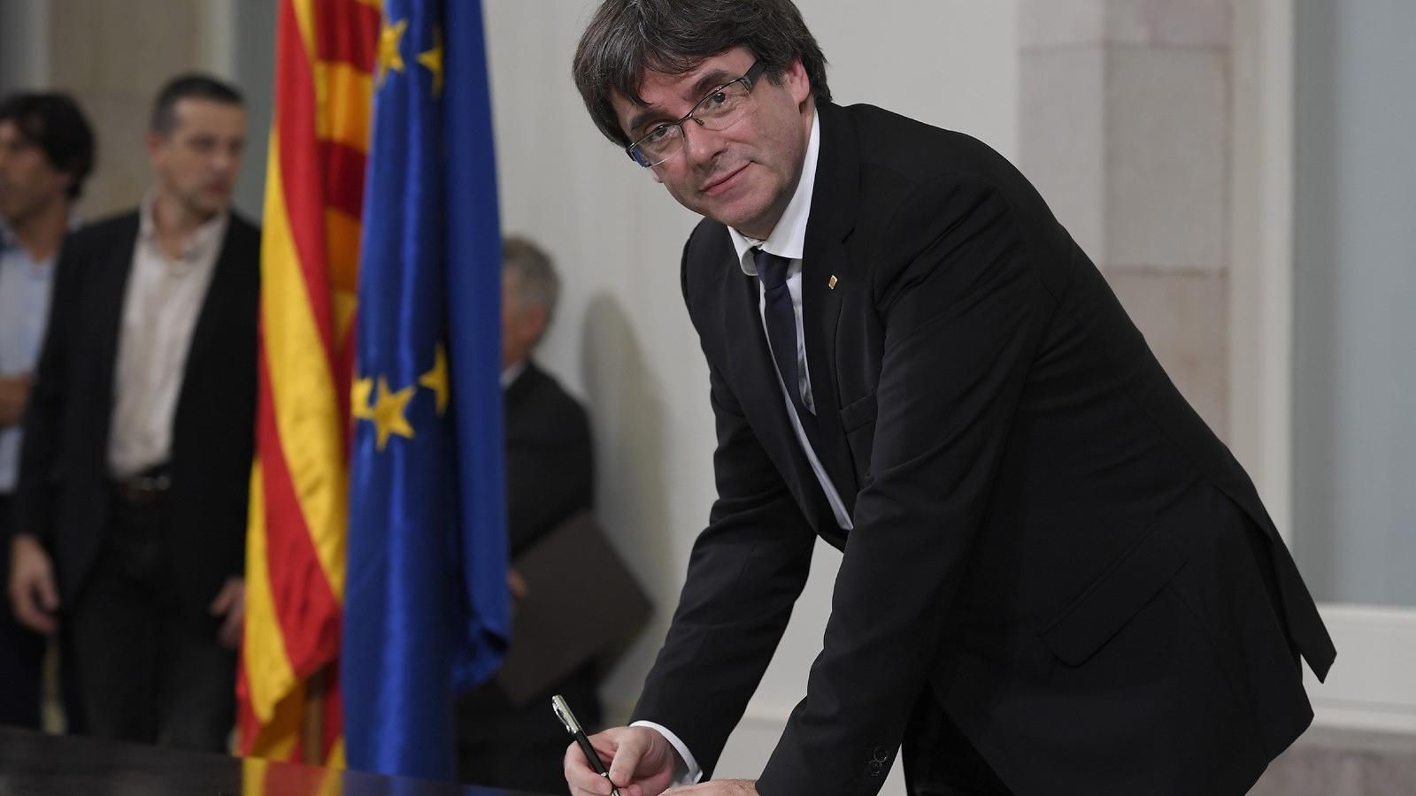 A katalán regionális kormány elnöke, Carles Puigdemont  aláírja a függetlenségről szóló dokumentumot. FOTÓ: LLUIS GENE / AFP