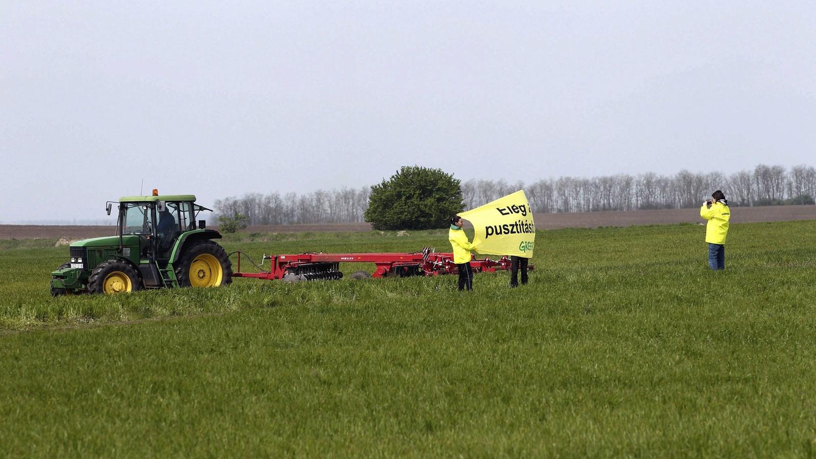 A Greenpeace aktivistái "ELÉG A PUSZTÍTÁSBÓL!" feliratú transzparenssel egy munkagép előtt a Fejér megyei Kishantoson 2014. ápri