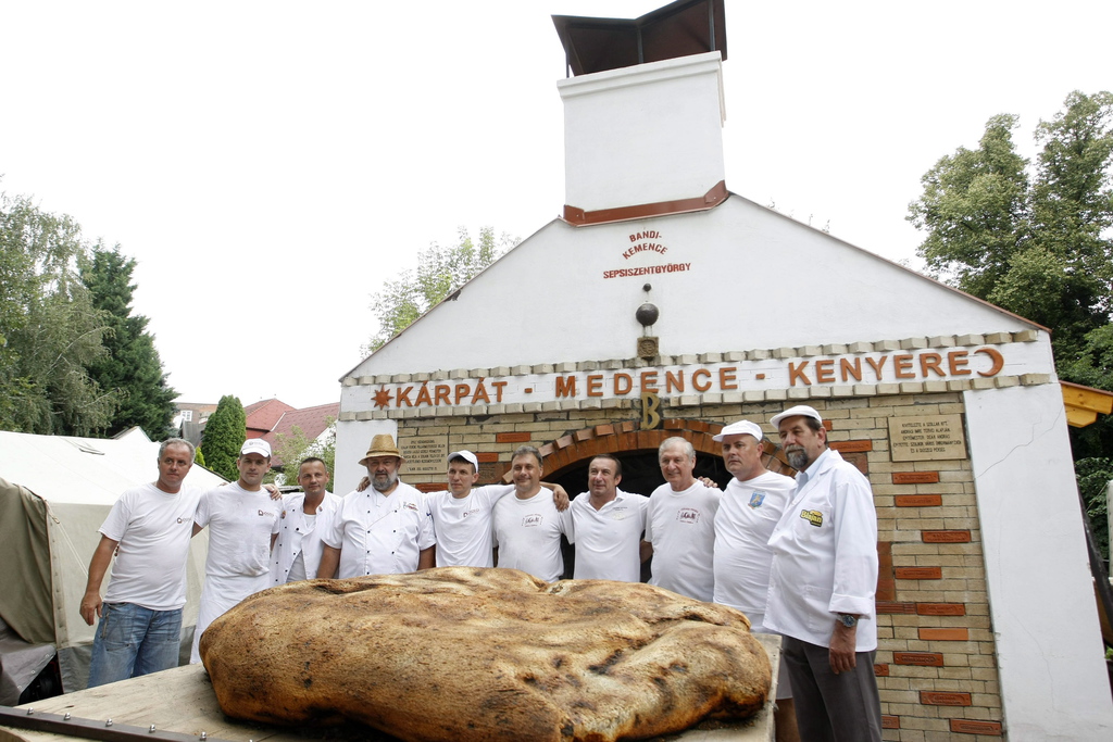  Pékek és segítőik a Kárpát-medence kenyerével a szolnoki művésztelepen 2014. augusztus 20-án. A határon túli településekkel együttműködve Szent István napjára elkészült 200 kilogrammos, pityókás kenyeret a megszentelés után szétosztják az ünneplők között. MTI Fotó: Bugány János