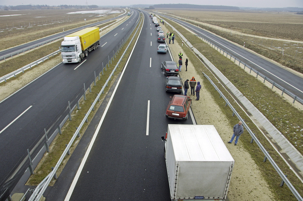 Félpályás útlezárás Szombathely határában, az M86-os autóút 85-ös kilométerszelvényénél. Civilek és hozzájuk csatlakozó helyi szocialisták az autóút mindössze 15 kilométer hosszú szakaszára bevezetett útdíj ellen tiltakoztak. MTI Fotó: Büki László