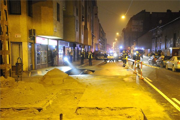 Tűzoltók és rendőrök Budapesten, a VIII. kerületi Karácsony Sándor utcában, ahol egy vélhetően csőtörés miatt keletkezett gödörbe esett egy személygépkocsi 2013. november 18-án. MTI Fotó: Mihádák Zoltán