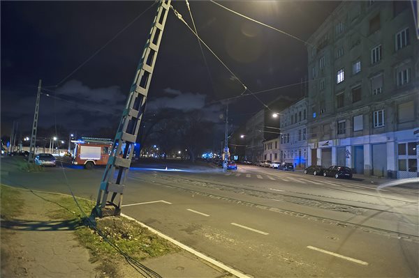 Megdőlt oszlop a VIII. kerületi Dobozi utcában, miután egy, a viharos erejű szél miatt kidőlt fa leszakította a 28-as és 37-es villamos felsővezetékét és autókat rongált meg és Budapesten 2013. december 7-én hajnalban.MTI Fotó: Lakatos Péter