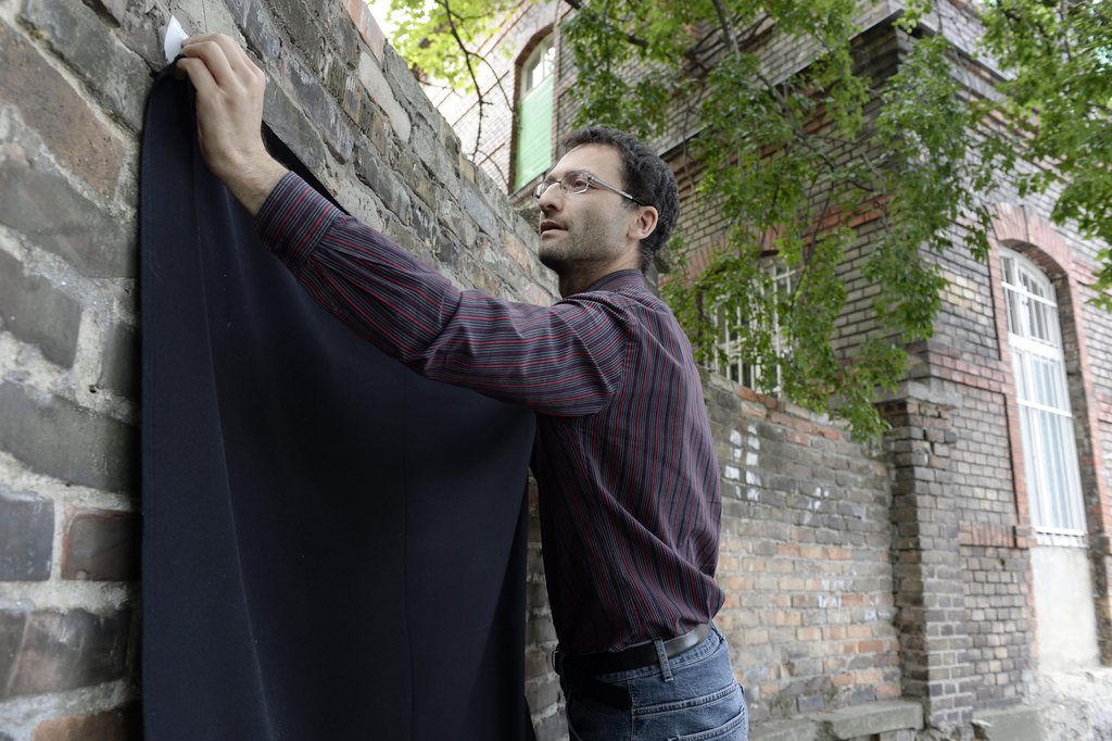 Erőss Gábor, a Párbeszéd Magyarországért elnökségi tagja fekete zászlót tesz a Merényi Gusztáv Kórház kerítésére az Eltemetjük a magyar beteget címmel tartott sajtótájékoztatón. MTI Fotó: Kovács Tamás